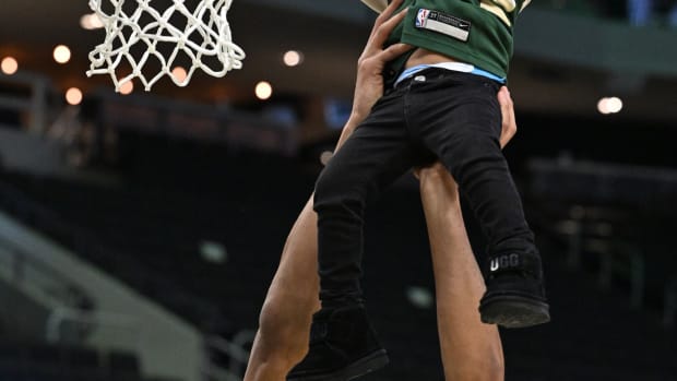Milwaukee Bucks forward Giannis Antetokounmpo (34) lifts his middle son Maverick up to dunk 